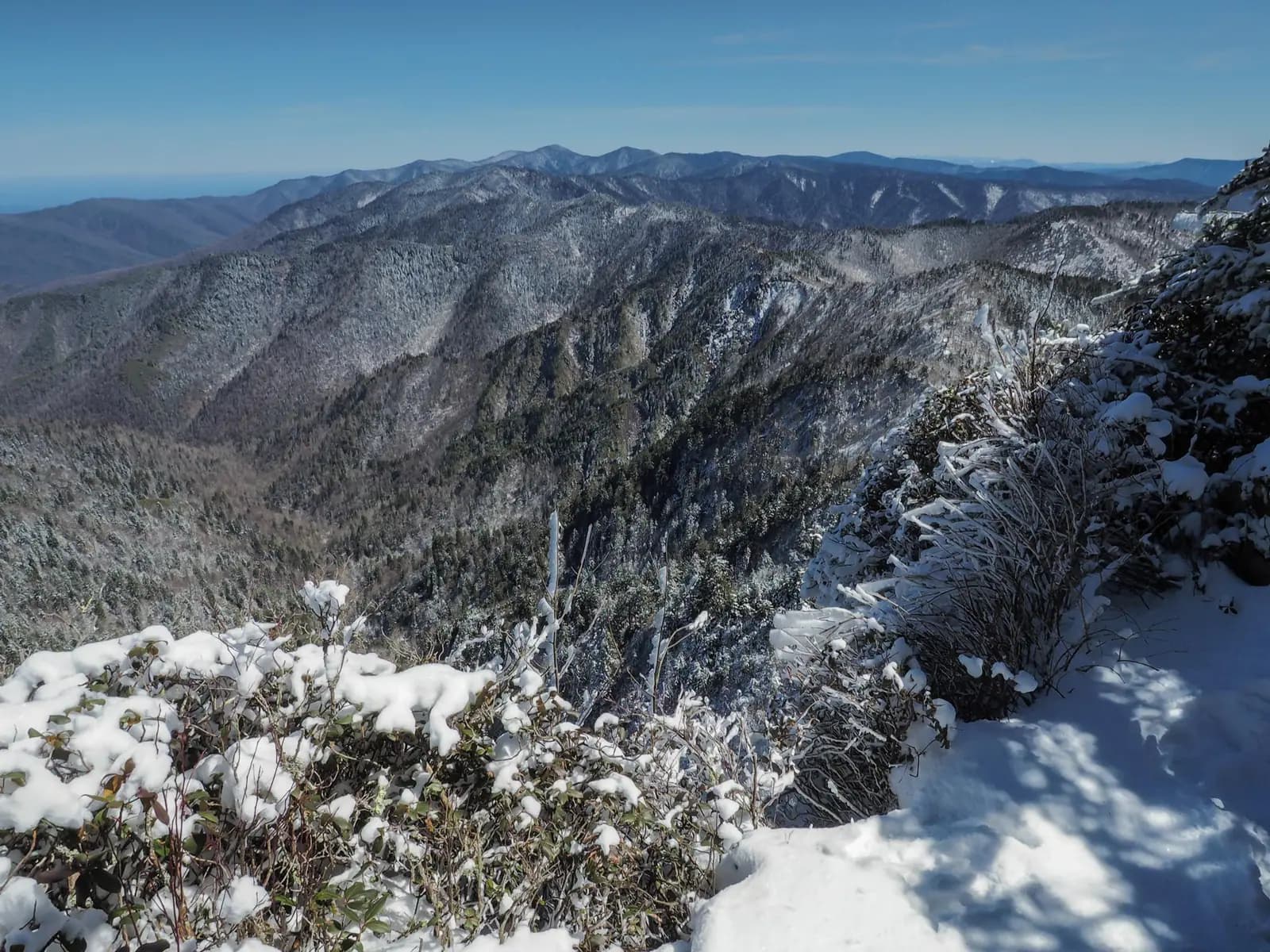 A clear sky with a vast snowy mountain scene.